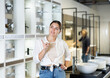 © JackF - in plumbing department, middle-aged woman thought about choosing suitable bathroom for new apartment