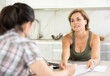 © JackF - Woman manager tells to girl client about specifics of design of microloan, about benefits and advantages. Female seller draws up contract on laptop