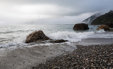 Wall Mural - Picturesque beach with small waves sea foam new zealand west coast