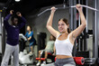© JackF - Caucasian woman training on lat pull down machine in gym