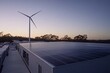 © mohdfaizal - Aerial View of a Rooftop Solar Panel Installation with a Wind Turbine in a Sustainable Energy Facility During Sunset in Nature