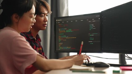 Slow motion back end software developer engineer for computer programming working together on debugging writing computing code, solving complex algorithms display on monitor in office. Burgeoning