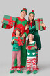 © Pixel-Shot - Happy family in elf's costumes with gift boxes on grey background