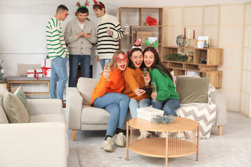 Sticker - Young women with champagne celebrating New Year at home party