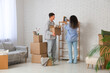 © Pixel-Shot - Young happy couple unpacking belongings near cardboard boxes in their new flat
