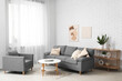 © Pixel-Shot - Comfortable sofa, armchair, coffee table and picture hanging on white brick wall in living room