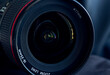 © banjongseal324 - Close-up camera lens,Close-up of a camera lens with bright light reflected in the glass details,Photo Camera or Video lens close-up on black background, objective, concept of photographer camera man j