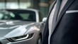 © tinnakorn - Stylish man in suit posing next to a luxurious car on city street