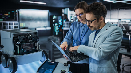 Leinwandbilder - Portrait of Male and Female Engineers Developing a Remotely Controlled Robot in an Industrial Research Facility. Specialists Using Laptop Computer, Working on Machine Improvement, Brainstorming 