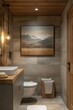 © Worawee - A bathroom with a toilet, sink, and a framed picture of mountains on the wall