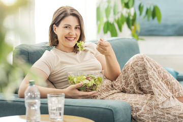 Happy woman having her lunch break in the living room