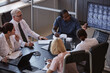 © Seventyfour - High angle shot of African American male radiologist pointing at screen explaining CT images of patients brain to colleagues at meeting, while collaboratively planning treatment at medical office