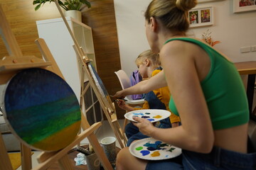 Wall Mural - A mother and her daughter are engaged in a painting session 