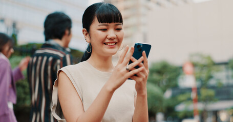Happy, travel and Asian woman with phone in city for communication, social media and networking. Smile, weekend and person on smartphone for online chatting, mobile app text and website in Japan
