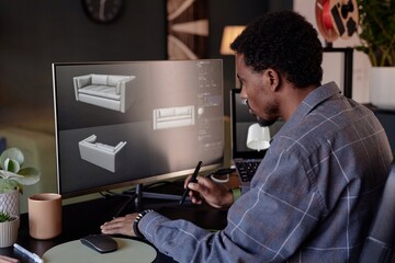Leinwandbilder - Man focusing on creating 3D models of furniture on a computer screen with stylus pen, showcasing various angles of a chair and a sofa