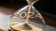 © Tekin - 2024 falling sand taking the shape of a 2024 in hourglass for Countdown to New Year 2025 concept.