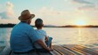 ©  lukaPixMedia - A man and a child sit together on a wooden dock, gazing at a beautiful sunset over a serene lake, symbolizing connection, reflection, and peacefulness.
