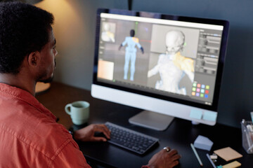 Leinwandbilder - Individual sitting at desk while handling a 3D modeling project on computer monitor. Background features various design tools on the screen and desk accessories