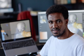 Leinwandbilder - Portrait of African American man standing near computer screen in office environment managing digital work and projects showcasing his professional dedication and workplace surroundings
