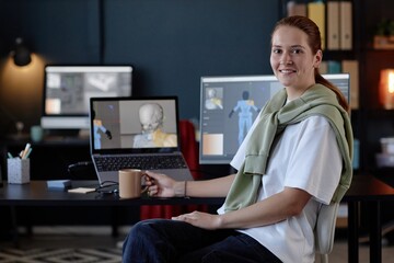 Leinwandbilder - Portrait of smiling woman working at desk with dual computer screens in modern office. Spacious and well-lit workspace features tech equipment and office supplies