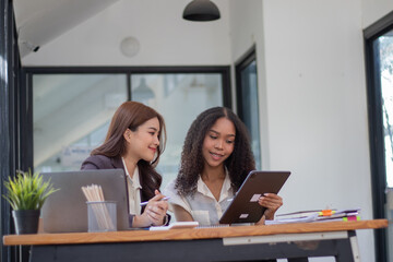 Professional business woman having online team meeting She sits in a sleek, modern workstation. Surrounded by technology such as laptops, smartphones and meeting tools. The screen shows a group of bus