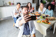 © Alessandro Grandini - Friends taking selfie while having lunch together at home