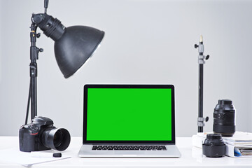 Wall Mural - laptop, green screen and table with space, photography equipment and camera. blank mockup, computer 