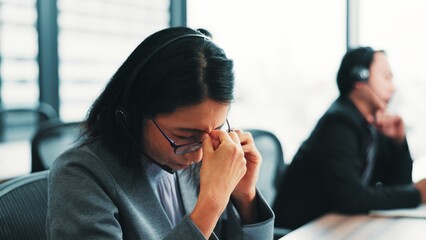 Tired, headache and Japanese woman in call center with stress, burnout or fatigue in office. Sad Asian consultant, upset or frustrated sales agent in telemarketing company with depression or migraine