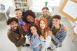 © Studio Romantic - Group portrait of a diverse, multinational business team standing together in the office. The happy group of people showcases a sense of community and collaboration within a professional environment.