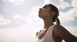 © Andrew/peopleimages.com - Outdoor, woman and running break with sweat or breathe for fitness, health and self care. Female person, sky and tired or exhausted with jogging as workout, training and exercise for wellness