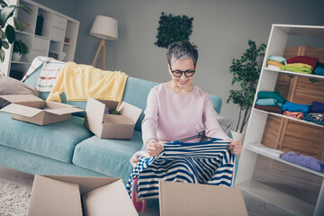 Wall Mural - Photo of positive good mood woman dressed pink sweatshirt packing old outfits indoors house apartment room