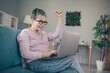 © deagreez - Photo of shiny lucky woman dressed pink sweatshirt winning game modern gadget indoors house apartment room