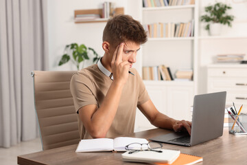 Wall Mural - Student studying with laptop at wooden table indoors