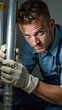 © Beniamin - Young caucasian male plumber fixing pipe with gloves in uniform
