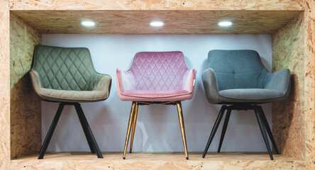 Poster - A row of wooden shelves with a variety of chairs on them. The chairs are of different colors and styles