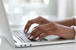 © zakiroff - Woman's hands typing on a laptop in a modern office, showcasing productivity and technology integration. Bright interior highlights communication and focus
