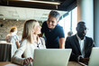 © Marko Geber - Business team collaborating on project in modern office environment