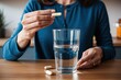 © Michael - Close-Up of Woman Taking Vitamin Pill with Glass of Water at Home