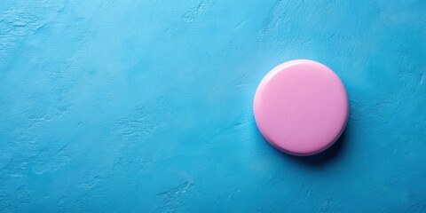 Fototapete - A single pink circle rests on a blue textured surface, providing a simple yet visually appealing composition.