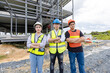 © Bangkok Click Studio - Asian man and woman construction engineer foreman workers wearing safety gear and helmet cross arms posing teamwork in the outdoors building construction site, a successful project in progress.