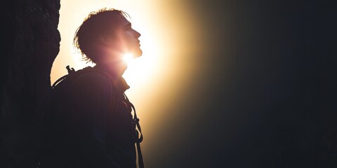 Wall Mural - A climber silhouetted against a bright background, representing the determination to ascend in life.