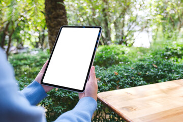 Wall Mural - Mockup image of a woman holding digital tablet with blank white desktop screen in the outdoors