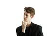 © peshkova - Young man in formalsuit with hand on chin, gazing thoughtfully to the side on a plain white background. Concept of thinking, decision-making