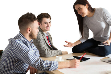 Wall Mural - Group of three young professionals discussing ideas with charts, sketches, and devices on a table, isolated on white background, teamwork concept