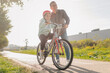 © Ljustina - Father teaching daughter riding bicycle in park during sunny day