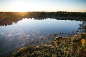 Wall Mural - a lake with a sun reflecting on the water