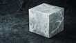 © daniel - Smooth matte stone cube placed on a contrasting textured surface in soft lighting