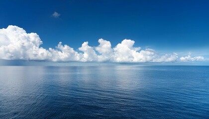 Wall Mural - white puffy clouds above calm sea