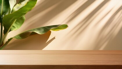 Wall Mural - wooden table counter top with beige wall and tropical banana plant in background with sunlight and dappled leaf shadow for luxury beauty organic health cosmetic jewelry fashion product display