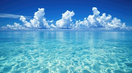 Wall Mural - clear blue sky with white fluffy clouds above a calm ocean, a peaceful seascape